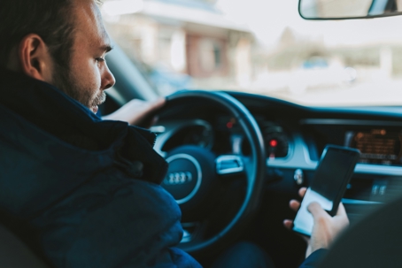 man in the car on his phone while driving