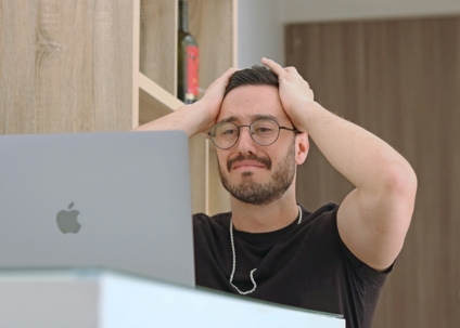 Man stressed out looking at laptop