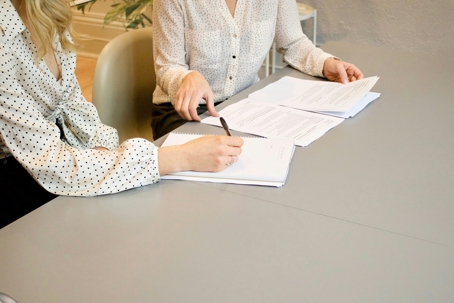 two women looking over and signing paperwork