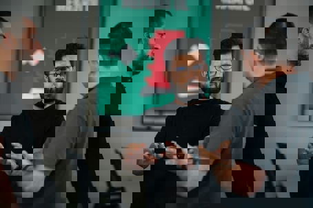 three men talking in a room