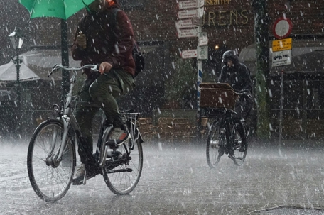 two people riding a bicycle in the rain